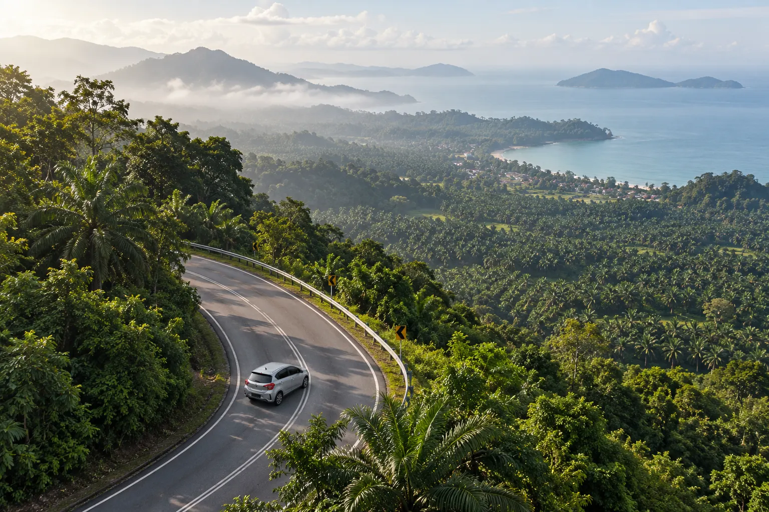 Aerial view of a Perodua Myvi on a winding coastal route between road trip destinations in Malaysia