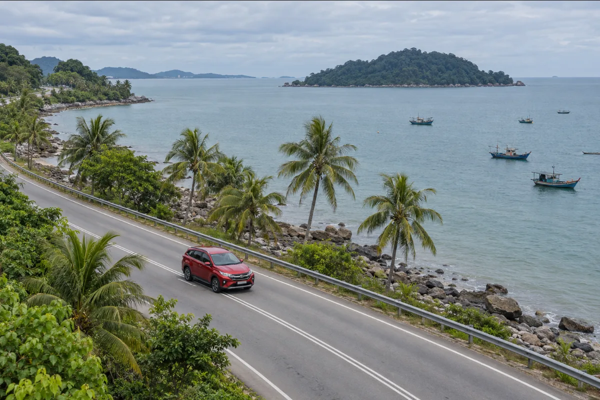 Red Perodua Aruz driving along a coastal road near Lumut in Perak, seen from above, on the way to a Pangkor Island day trip from Kuala Lumpur